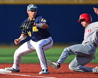 KENT, OHIO - APRIL 13, 2016: Third basemen Dylan Rosa #28 of Kent State keeps his foot on the bag to force out base runner Lorenzo Arcuri #9 of YSU for the 1st out in the top of the 1st inning during Wednesday nights game at Schooner Stadium. DAVID DERMER | THE VINDICATOR