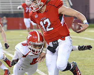 Jeff Lange | The Vindicator  FRI, APRIL 15, 2016 - YSU red team quarterback Ricky Davis (12) rushes out of bounds as he is tackled by white's Lee Wright in the third quarter of Friday night's spring game at Stambaugh Stadium in Youngstown.