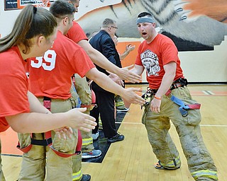 Jeff Lange | The Vindicator  FRI, APRIL 22, 2016 - Team Fire captain Kevin Bloom (right) high fives teammates during pregame announcements of the Guns vs. Hoses game at Howland High School Friday night.