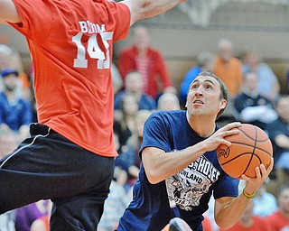 Jeff Lange | The Vindicator  FRI, APRIL 22, 2016 - Patrolman Marcus Coonce of Team Police (right) looks to the basket past Team Fire's Kevin Bloom in the first half of Friday night's Guns vs. Hoses charity basketball game held at Howland High School.