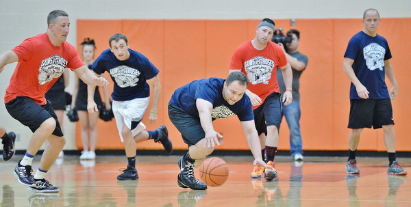 Jeff Lange | The Vindicator  FRI, APRIL 22, 2016 - Team Police's Patrolman Jonathan Coleman (center) dives for a loose ball as a host of Team Fire and Team Police players trail from behind in the first half of Friday night's charity basketball game at Howland High School.