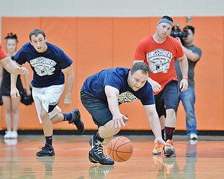 Jeff Lange | The Vindicator  FRI, APRIL 22, 2016 - Team Police's Patrolman Jonathan Coleman (center) dives for a loose ball as a host of Team Fire and Team Police players trail from behind in the first half of Friday night's charity basketball game at Howland High School.