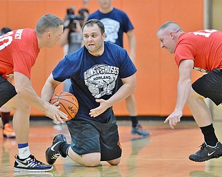 Jeff Lange | The Vindicator  FRI, APRIL 22, 2016 - Team Police's Jonathan Coleman (center) maintains possession of the ball between Team Fire's Corey Manofsky (left) and Lucas Kuzma in the first half of Friday night's Guns vs. Hoses charity basketball game at Howland High School.