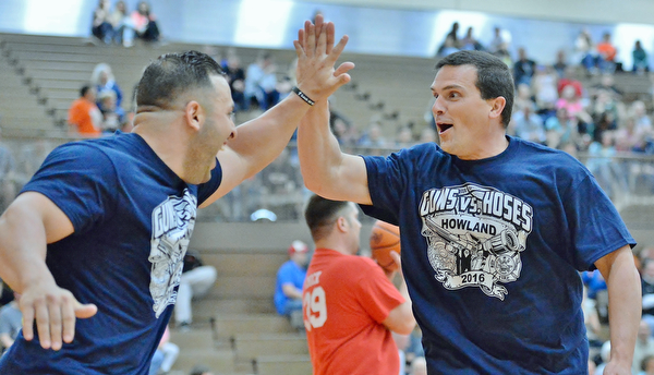 Jeff Lange | The Vindicator  FRI, APRIL 22, 2016 - Team Police's Patrolman Mark Klaholz (right) celebrates with Bryan Butto after a basket in the first half of Friday's Guns vs. Hoses basketball game in Howland.