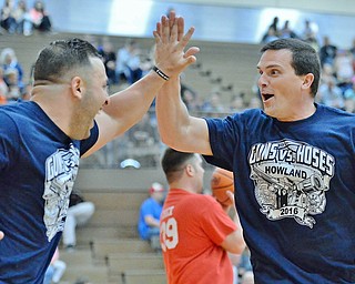 Jeff Lange | The Vindicator  FRI, APRIL 22, 2016 - Team Police's Patrolman Mark Klaholz (right) celebrates with Bryan Butto after a basket in the first half of Friday's Guns vs. Hoses basketball game in Howland.