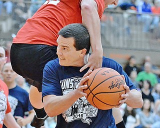 Jeff Lange | The Vindicator  FRI, APRIL 22, 2016 - Team Police's Patrolman Mark Klaholz attempts a shot under the defensive efforts of Team Fire's Lucas Kuzma in the first half of Friday's Guns vs. Hoses charity basketball game held at Howland High School. Funds raised at the event went toward football stadium renovations.