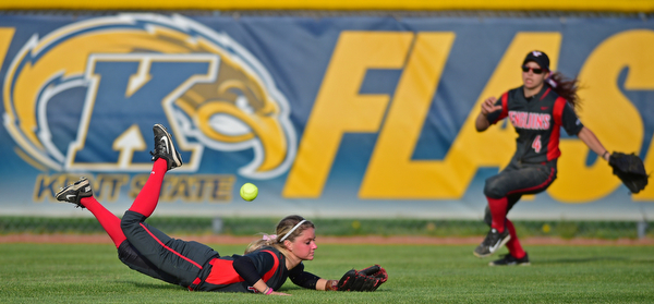 KENT, OHIO - APRIL 27, 2016:  Center fielder Jordan Macey #10 of YSU slides on the turf after unsuccessfully diving to catch the ball while Cali Mikovich #4 goes after the ball in the fifth inning of game two Wednesday night at the Diamond at Dix. Kent State won game two 3-2. DAVID DERMER | THE VINDICATOR