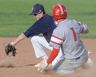 Jeff Lange | The Vindicator  WED, APRIL 27, 2016 - Fitch second baseman Jack Gherardi (left) attempts to scoop up a throw from the plate as Niles baserunner Garrett Pitts slides safely into the bag in the top of the fifth inning of Wednesday's game at Fitch High School.