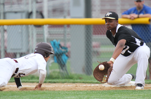 Williiam D Lewis the vindicator Boardman Luke Cardillo(12) dives back to first as Warren's Grant Williams(1) waits for the throw at first during game at  Boardman May 12-16.
