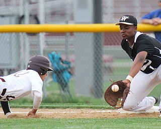 Williiam D Lewis the vindicator Boardman Luke Cardillo(12) dives back to first as Warren's Grant Williams(1) waits for the throw at first during game at  Boardman May 12-16.