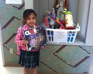 SPECIAL TO THE VINDICATOR | Students at St. Patrick School in Hubbard are helping to raise money for the family of Hannah Tringhese, 6, a kindergarten student at Struthers Elementary School who has been diagnosed with a rare brain tumor. Classroom doors have signs that say “Pray for Hannah” to remind students to keep Hannah and her family in their daily prayers. The students also have sponsored activities to raise additional funds, including two “Purple Dress Down Days” in April, in which students and staff paid $1 or more to not wear uniforms or professional attire, but to dress in Hannah’s favorite color. Other activities included donations of items to fill baskets for a basket raffle as part of a spaghetti dinner fundraiser and purchases of “Hannah Strong” T-shirts and bracelets made by Hannah’s cousin, Lia Fiorini, a second-grade student. Above, Leeana Cortes, a first-grader, puts a game in one of the donation baskets for Hannah.