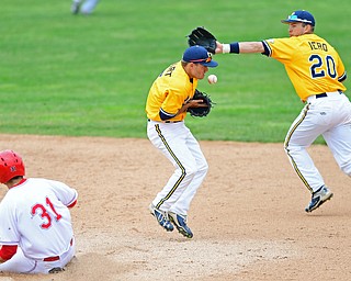 NILES, OHIO - MAY 17, 2016: Sam Hurt #5 of Kent State bobbles the baseball while Dom Iero #20 reaches for the ball while Gerrad Rohan #31 of YSU slides into second after a bad throw to first base lead to a bad throw to second base in the sixth inning of Tuesday afternoons game at Eastwood Field. YSU won 11-10 in eleven innings. DAVID DERMER | THE VINDICATOR