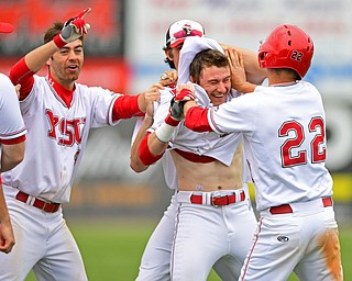 NILES, OHIO - MAY 17, 2016: Alex Larivee (center) of YSU is moved by his teammates including Jonny Miller #22 and Billy Salem #18 after driving int he game winning run in the eleventh inning of Tuesday afternoons game at Eastwood Field. YSU won 11-10 in eleven innings. DAVID DERMER | THE VINDICATOR