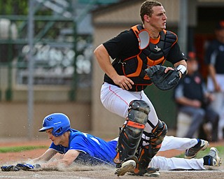 STRUTHERS, OHIO - MAY 20, 2016: Matt Baker #11 of Poland slides across home plate to score a run behind catcher Tyler Tokos #27 of Marlington in the sixth inning of Friday nights game at Cene Park. Poland Won 7-6. DAVID DERMER | THE VINDICATOR