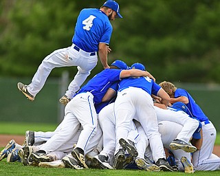 STRUTHERS, OHIO - MAY 20, 2016: Anthony Calcagni #4 of Poland jumps onto the dog pile on top of Dan Klase #24 after he drove him the game winning run in the bottom of the seventh inning of Friday nights game at Cene Park. Poland Won 7-6. DAVID DERMER | THE VINDICATOR