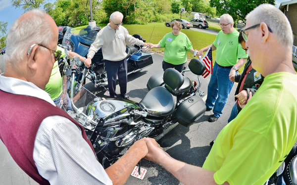 Jeff Lange | The Vindicator  SUN, MAY 22, 2016 - Members of the First Baptist Church of Hubbard gather hand-in-hand to say a prayer over Frank Rickman's motorcycle during Sunday's second annual Blessing of the Bikes in Hubbard.