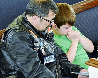 Jeff Lange | The Vindicator  SUN, MAY 22, 2016 - Frank Rickman and son Carter, 9, of Sharpsville, Pa. bow their heads in a moment of prayer during Sunday's service at the First Baptist Church of Hubbard prior to the church's second annual Blessing of the Bikes ceremony.
