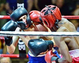 Jeff Lange | The Vindicator  WED, MAY 25, 2016 - LaBrae's Brandon Woolard (left) takes a right hook to the face from Sharon's Calvin Davis during their super featherweight bout during the 2016 K.O. Drugs High School Boxing Championships at the Old South Range Gym on Wednesday.