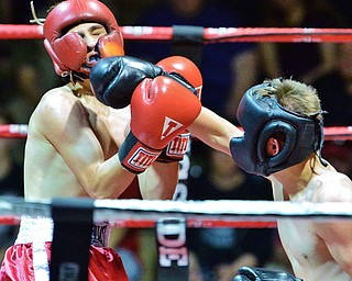 Jeff Lange | The Vindicator  WED, MAY 25, 2016 - Girard's Bryce Jones (left) takes a jab to the face from Canfield's Nate Cordova during their junior welterweight bout during the 2016 K.O. Drugs High School Boxing Championships at the Old South Range Gym on Wednesday.