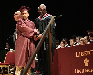 Nikos Frazier | The Youngstown Vindicator..Arwan Clinkscale, Liberty High School class of 2016, receives his diploma from Calvin Jones, President of the Board of Education, in  Edward W. Powers Auditorium on Thursday, May 26, 2016.