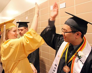 William d Lewis the Vindicator  HARding grads Lexi Meade and JAson Lee hi-5 during commencement ceremony 5-26-16 at Packard Music Hall in Warren