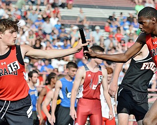 Jeff Lange | The Vindicator  THU, MAY 26, 2016 - Girard's Kenny Walters (15) takes a baton from teammate Micah Jones in the boys 4x800 meter relay finals during Thursday' Division II regional track meet at Austintown Fitch High School.