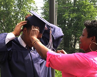 Nikos Frazier | The  Vindicator.Faith Harris-Jefferson(right) fixes her son, Bobby Jefferson's cap(left) outside of Packard Music Hall after he recieved his diploma from John F. Kennedy Catholic School