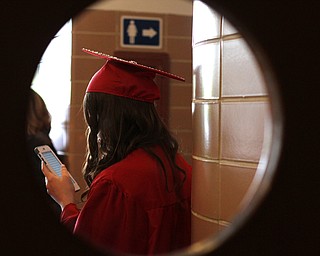 Nikos Frazier | The  Vindicator.Jaclyn Rowley looks at her phone in the hallway of Packard Music Hall in Warren before receiving her diploma from Niles McKinley High School. Rowley is one of two valedictorians for the McKinley class of 2016.