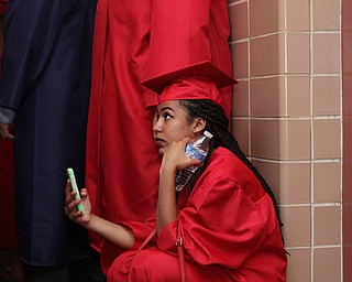Nikos Frazier | The  Vindicator.Alasia Williams kneals in the hallway of Packard Music Hall as she waits to line up before Niles McKinley's commencement ceromonies on Saturday, May 28, 2016.