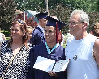 Nikos Frazier | The  Vindicator.Cindy(left) and George(right) Rutherford pose with Dylan Walker outside of Packard Music Hall after Walker received his diploma from Niles McKinley High School.