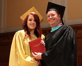 Nikos Frazier | The Vindicator..Anne Alcorn receives her Cardinal Mooney High School diploma from Principal Mark Vollmer.