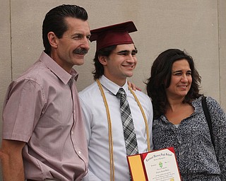 Nikos Frazier | The Vindicator..Nicholas Koken(center) poses with his parents outside of Stambaugh Auditorium after receiving his diploma from Cardinal Mooney High School.