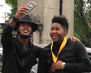 Nikos Frazier | The Vindicator..Daekwaun Thomas(left) and Malik Everson snap a selfie outside of Stambaugh Auditorium after Everson graduated from Ursline High School.