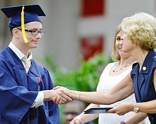 Jeff Lange | The Vindicator SUN, MAY 29, 2016 - Van Blevins shakes hands with Kathy Mock as he receives his diploma during Sunday's commencement at Austintown Fitch High School.