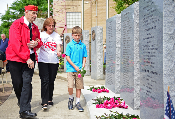 STRUTHERS, OHIO - MAY 30, 2016: Marine Alex Sepesy (left) escorts Mary Ann Johnston and her grandson Aiden Johnston of Struthers the fallen soldier memorial so they can place a rose in memory of her son CPL Edward A. Johnston who was killed in action in Lebanon in 1983, during a fallen soldier memorial dedication at Struthers High School. DAVID DERMER | THE VINDICATOR