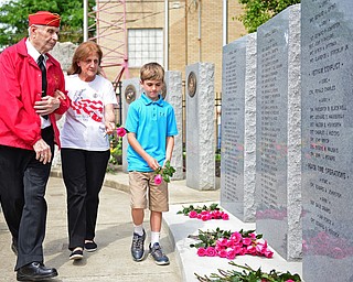 STRUTHERS, OHIO - MAY 30, 2016: Marine Alex Sepesy (left) escorts Mary Ann Johnston and her grandson Aiden Johnston of Struthers the fallen soldier memorial so they can place a rose in memory of her son CPL Edward A. Johnston who was killed in action in Lebanon in 1983, during a fallen soldier memorial dedication at Struthers High School. DAVID DERMER | THE VINDICATOR