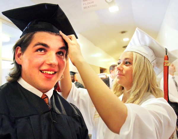 William D. Lewis\The Vindicator.Graduating Howland senior Nick Bell gets help with his cap from fellow grad Sarah Brindley before Wednesday June 1, 2016 commencement at Packard Music Hall in Warren.