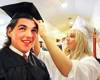 William D. Lewis\The Vindicator.Graduating Howland senior Nick Bell gets help with his cap from fellow grad Sarah Brindley before Wednesday June 1, 2016 commencement at Packard Music Hall in Warren.