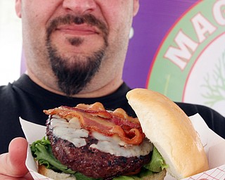 William D. Lewis\The Vindicator.John "Tank" Jurcisin, chef at Magic Tree Pub and Eatery in Boardman shows off one of creations at the Burgers and Beards Festival in downtown Youngstown June 3, 2016.