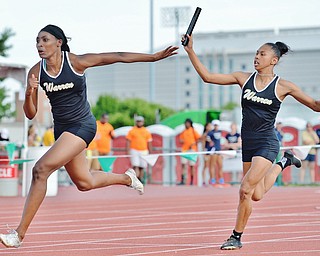 Jeff Lange | The Vindicator  FRI, JUN 3, 2016 - Warren Harding's Aisha Jackson (left) takes the handoff from teammate Gariana Bercheni in the girls 4x100 meter relay during Friday's OHSAA State Track and Field tournament at Jesse Owens Memorial Stadium in Columbus. Harding placed second with a qualifying time of 47.93 seconds.