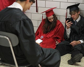 Nikos Frazier | The Vindicator..Students from Canfield High School class of 2016 look at their phones while waiting to enter the Canfield High School Gym to receive their diplomas.