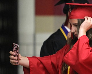 Nikos Frazier | The Vindicator..Theresa Nikolay looks at her phone before graduating from Canfield High School on Sunday.