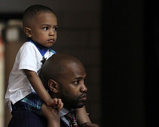 Nikos Frazier | The Vindicator..Kent Barnes III, 2, sits on his dad, Kent Barnes' shoulders as they watch their relative, British Wagner, graduate from Canfield High School on Sunday, June 5, 2016.