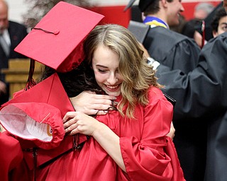 Nikos Frazier | The Vindicator..Nicole Schmidt hugs her classmate after graduating from Canfield High School.