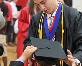 Nikos Frazier | The Vindicator..Troy Williams puts his cap on his brother, McCoy Reid's, 5, head after Williams graduated from Canfield High School.