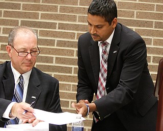        ROBERT K. YOSAY  | THE VINDICATOR..krish and brian benyo.. sign 'the contract.'..Krish Mohip, a Chicago schools administrator, is the first Ytown schools CEO. - -30-......
