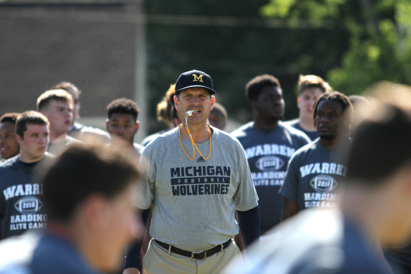 Nikos Frazier | The Vindicator..Jim Harbaugh, Michigan  Football Head Coach, watches as players run during the Warren Harding Elite Camp.