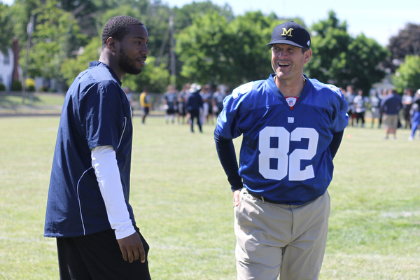 Nikos Frazier | The Vindicator..Jim Harbaugh(right), Michigan Football Head Coach, and Mario Manningham(left) smile as they catch up during the Warren Harding Elite Camp. Manningham, originally from Warren, played for Harbaugh and the 49ers in 2012 and 2013 as well as Michigan State in college.