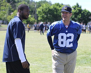 Nikos Frazier | The Vindicator..Jim Harbaugh(right), Michigan Football Head Coach, and Mario Manningham(left) smile as they catch up during the Warren Harding Elite Camp. Manningham, originally from Warren, played for Harbaugh and the 49ers in 2012 and 2013 as well as Michigan State in college.