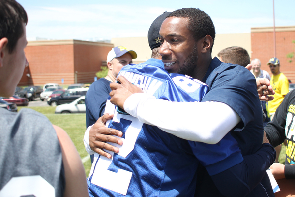 Nikos Frazier | The Vindicator..Jim Harbaugh(left), Michigan  Head Coach, embraces Mario Manningham(right), after the Warren Harding Elite Camp. Manningham, originally from Warren, played for Harbaugh and the 49ers in 2012 and 2013 as well as Michigan State in college.